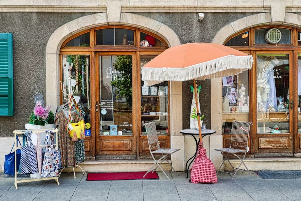 A store front with an umbrella and chairs outside