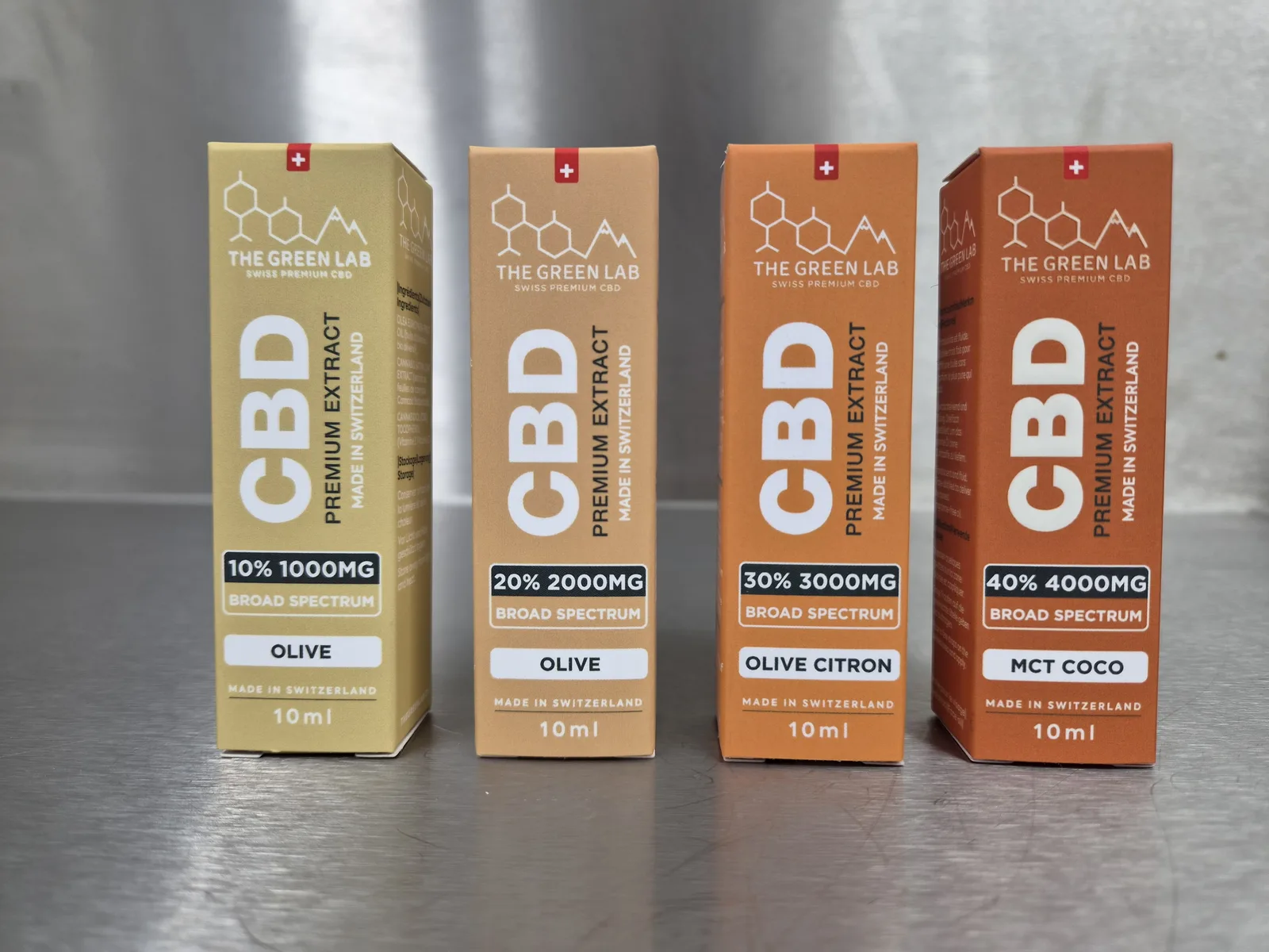 Vier Faltschachteln des CBD-Öls Broad Spectrum 10 ml: 10 % und 20 % auf Olivenöl, 30 % auf Olivenöl mit Zitrone, 40 % auf MCT-Kokosöl
