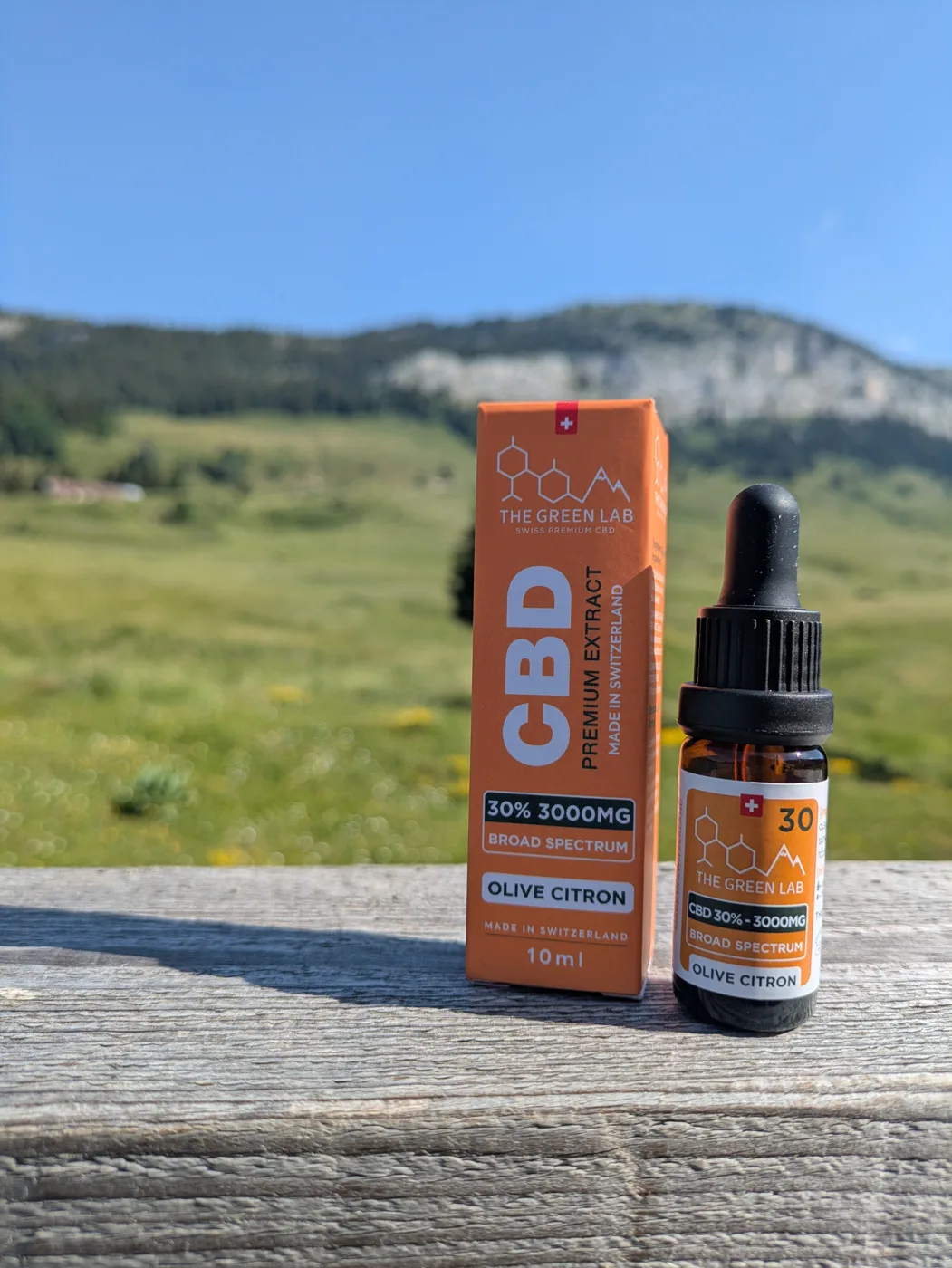 CBD-Öl Broad Spectrum 30 % Olive Zitrone, Flasche und Schachtel vor einer Weide